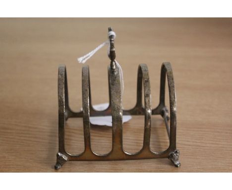 George V silver toast rack, Birmingham 1927, maker Walker &amp; Hall, with pierced finial above four divisions, raised on scr