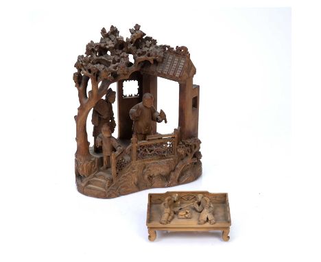 Two Chinese wood carvingsthe first depicting a family group under a pagoda, the male figure holding a bird in one hand 24cm h