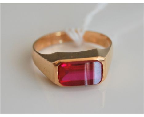 A synthetic ruby ring, the fancy cut rectangular ruby, in rubover mount, marks rubbed, (tests as approx. 18ct), size O-P, (4.