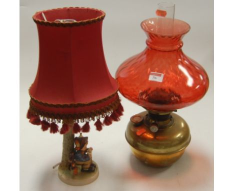 A Hummel bedside lamp with silk shade, together with a Hinks Duplex oil lamp with cranberry glass shade (2)