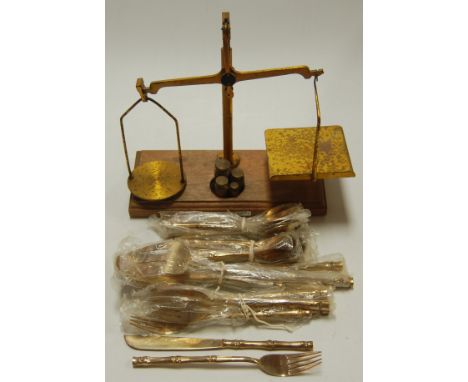 A balance scale with weights together with a gilt metal part cutlery suite