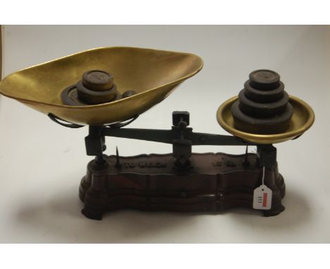 A cast iron pan scale with weights and brass trays 