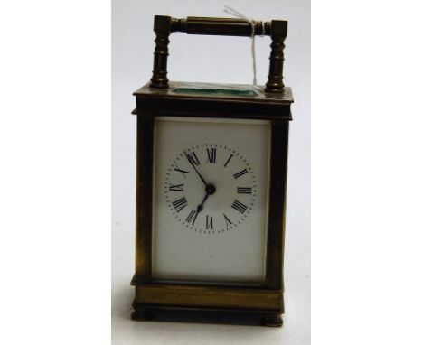 An early 20th century lacquered brass cased carriage clock having enamel dial with Roman numerals, visible platform lever esc
