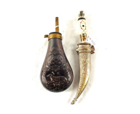 A powder flask with embossed dog and game birds with a decorative dagger