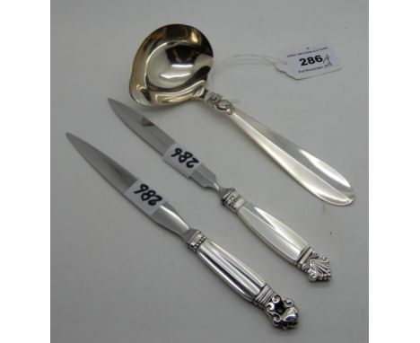 A lot comprising two sterling silver handled knives by Georg Jensen, 13cm long and a Danish silver sauce ladle (3) Condition 