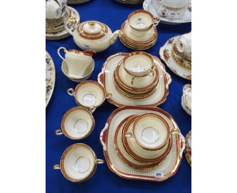 An Ainsley teaset, the cream ground with gilt and maroon decoration comprising two cake plates, twelve cups, eleven saucers, 