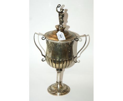 A silver plated trophy cup, twin handled with lower half of the body lobed and the cover with figural finial, inscribed "Pres