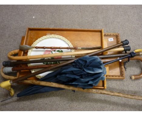 Two vintage wooden trays and one other and a quantity of walking sticks, canes and a vintage umbrella