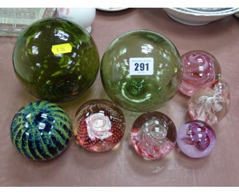 Two green glass fishing net floats and a collection of vintage paperweights