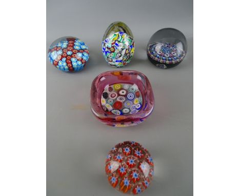 Four vintage millefiori decorated paperweights and a similar bowl with cranberry tint