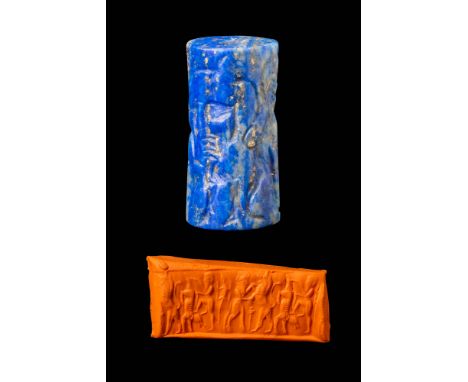 Ca. 2350 - 2150 BC. A lapis lazuli cylinder seal engraved with two human figures accompanied by feline-like creatures. The fi