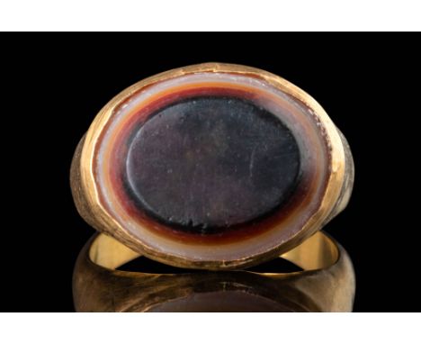 Ca. 300 - 100 BC. A convex gemstone of banded agate with parallel layers of translucent, opaque white, and brown, with the da