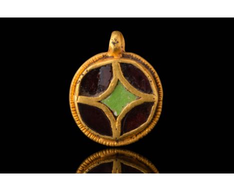 Ca. AD 400 - 600. A gold pendant with a circular flat body and a suspension loop at the top. The front face is decorated with