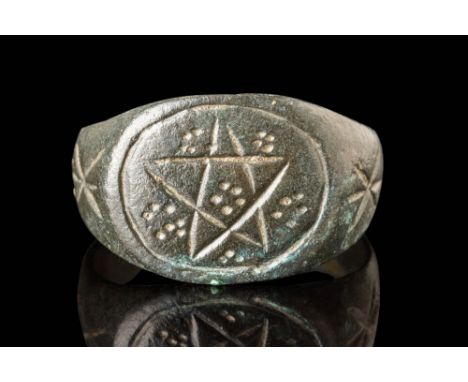 Ca. AD 300 - 400. A bronze ring with a broad, flat-section hoop that gradually widens towards the bezel, where a five-pointed