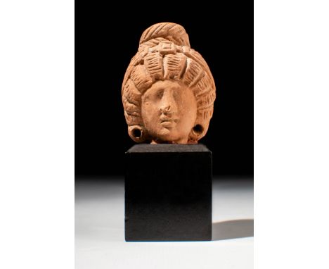 Ca. 30 BC - AD 200.A terracotta female head with recessed areas for the eyes, delicate brows, a straight nose, and full lips.