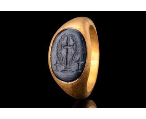 Ca. AD 500 - 600. An oval black intaglio engraved with a Latin cross standing on a stepped base, flanked by two smaller cross