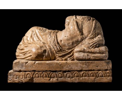Ca. 300 - 200 BC. An Etruscan funerary urn lid from Volterra depicts a reclining naked man adorned with a flower necklace scu