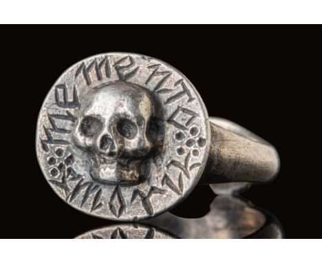 Ca. AD 1600.A silver ring with a circular bezel featuring a raised skull at its centre, its hollowed eye sockets and nasal ca