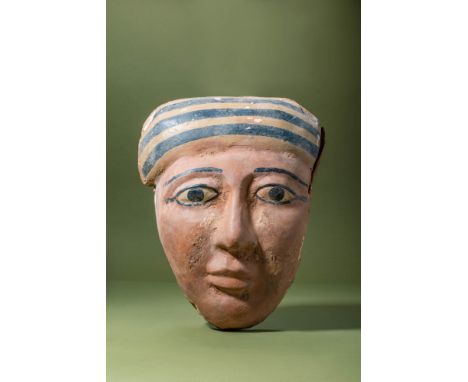 Late Period, Ca. 664-332 BC.A wooden mummy mask from the lid of an anthropoid coffin, painted in pigment over a gesso layer. 