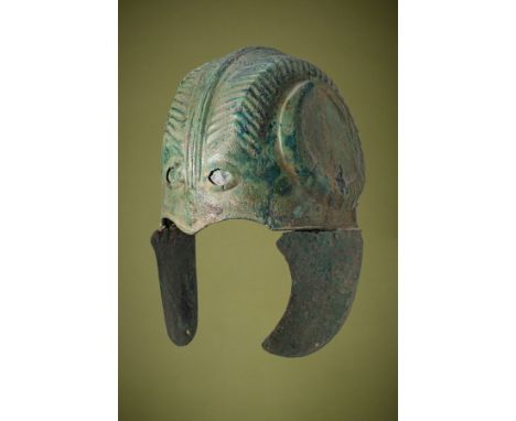 Ca. 400 - 300 BC. A rare Chalcidian bronze helmet with angular ribs hammered outwards on each side. The helmet is adorned wit