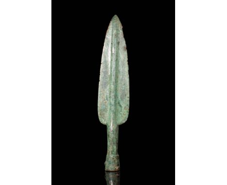Ca. 900 - 700 BC. A bronze spearhead with an elongated leaf-shaped blade tapering to a sharp point. The blade features a pron
