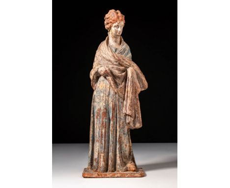 Ca. 325 - 280 BC. A painted terracotta figurine depicting a standing female with detailed facial features, a softly modelled 