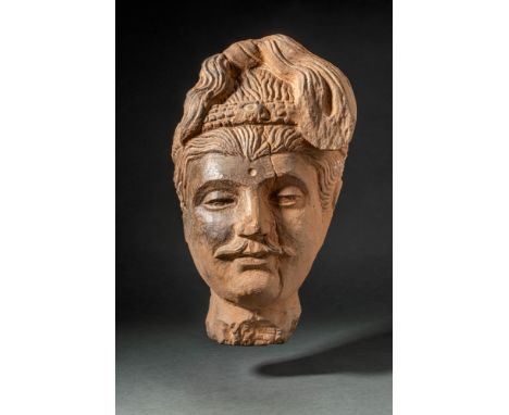 Ca. AD 200 - 400. A carved stone head of Buddha. The serene face depicts deep set almond eyes, with the urna and lobed ears. 