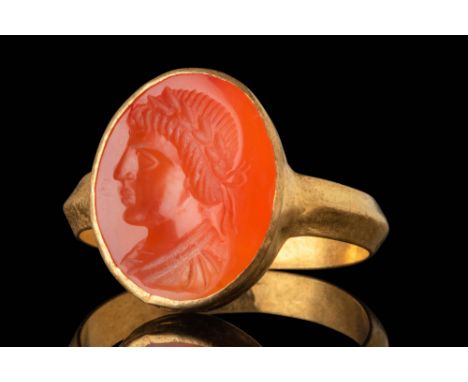 Ca. AD 100 - 300. A carnelian intaglio engraved with a left-facing bust of an emperor wearing a laurel wreath. His facial fea
