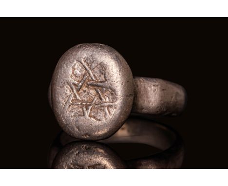 Ca. AD 1200 - 1300. A silver merchant's seal ring composed of a solid, rounded hoop with chamfered shoulders. The protruding 