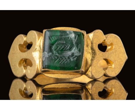 Ca. AD 300.A green glass intaglio depicting a scorpion with a segmented body, curved tail, and extended pincers. The intaglio