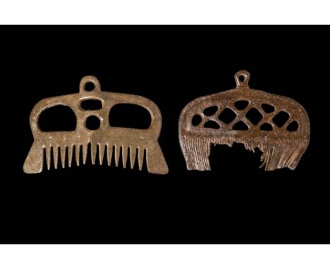 Ca. AD 800 - 1100. A pair of bronze combs, each with an openwork design and a suspension loop at the top. The teeth are evenl