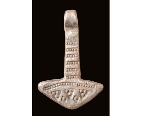 Ca. AD 900 - 1000.A silver Mjölnir pendant with a vertical shaft extending from a broad, angular head. The shaft is decorated