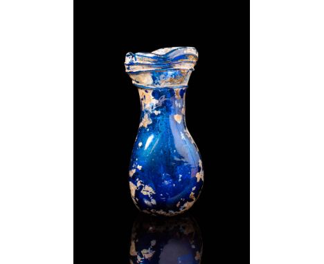 Ca. AD 200 - 400. A cobalt blue glass bottle with a pear-shaped body tapering into a slender neck, which expands into a broad