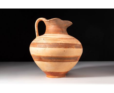 Ca. 400 - 300 BC. A pottery oinochoe with an inverted pear-shaped body resting on a ring base. It has a squat neck with a tre