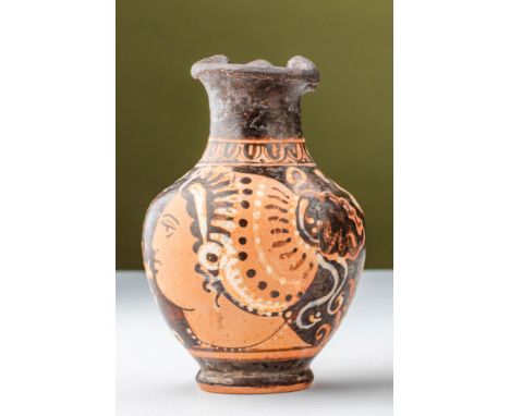 Ca. 400 - 300 BC.A terracotta oinochoe decorated with a portrait of a Lady of Fashion in the red-figure technique. The vessel