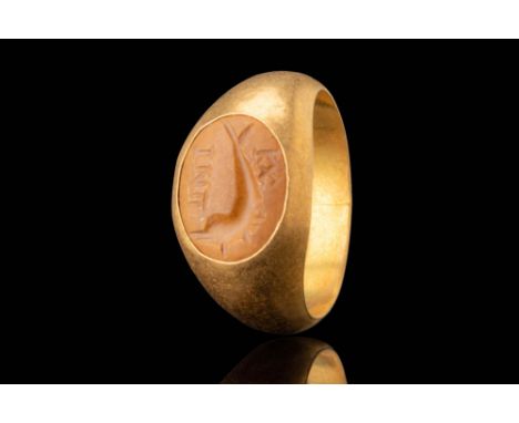 Ca. AD 100 - 300. An oval stone intaglio engraved with a dolphin, its body curving with an elongated snout and a slightly for