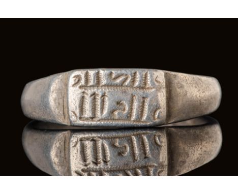 Ca. AD 700.A silver ring with a rectangular bezel engraved with pseudo-script arranged in two horizontal lines. The character