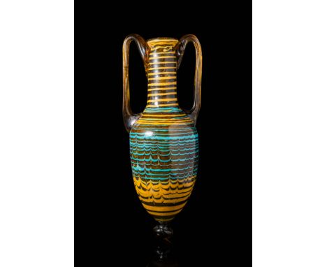Ca. 150 BC - AD 50. A core-formed amphoriskos in amber-coloured glass with an elongated, inverted piriform body tapering to a