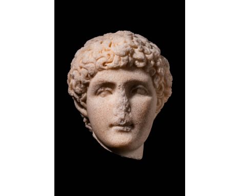 Ca. AD 200 - 300. A marble head of a youth with a smooth, rounded face with full cheeks and a straight nose. The eyes are dee