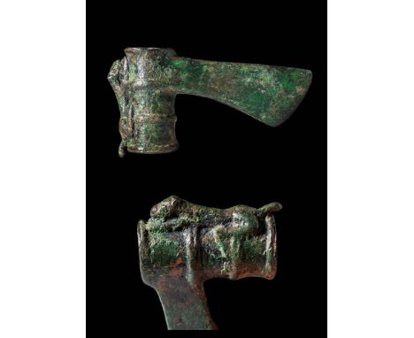 Ca. 1000 - 900 BC. A bronze axe head featuring a tubular socket with thickened collars around its openings and two horizontal