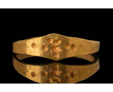 Ca. AD 500 - 800.A flat-section gold ring with a hoop that slightly widens towards the bezel, which has an angular profile. T