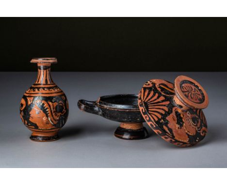 Ca. 400 - 300 BC. A pair of red-figure pottery vessels, including a lekythos and a lekanis with its lid. The lekythos has a s