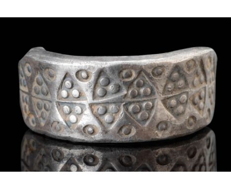 Ca. AD 800 - 1000. A ring formed from a flattened silver rod with a broad, flat-section band that tapers at both ends into a 