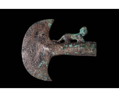 Ca. 900 - 800 BC. A bronze axe head with a long tubular shaft extending to a crescent-shaped flat blade with pointed tips. Th
