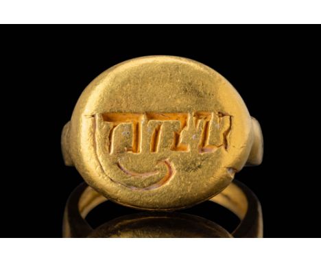Ca. AD 850 - 950. A gold signet ring with a broad, rounded bezel inscribed with a deeply cut Kawi script. The shoulders taper