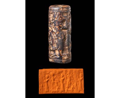 Ca. 8th - 6th century BC. A black stone cylinder seal depicting an enthroned deity with a crouching bull and a warrior deity 