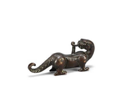 A Chinese bronze scroll weight, 17th or 18th century, cast as a standing tiger with its head turning backwards, 9.8cm long, w