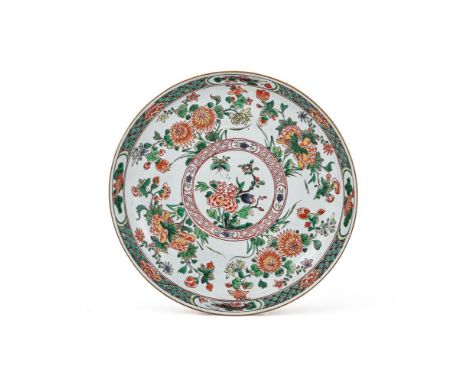 A large Chinese Famille Verte Dish, Kangxi, with flowers including peonies and chrysanthemum and the rim with four panels dec