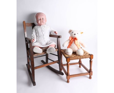 A vintage doll, a '2015' Steiff bear, a miniature rocking chair and a miniature foot stool.