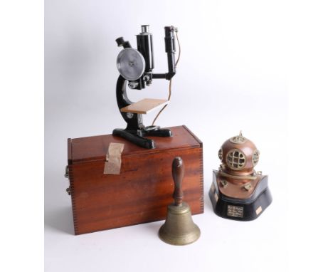 An old A.R.P. bell, a Bank Of England sub aqua diving officers award in a form of a vintage diving helmet and a boxed microsc